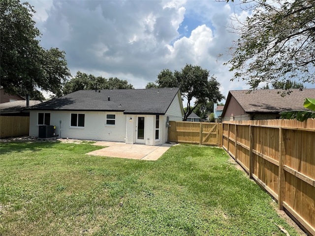 rear view of property with a lawn, central AC, and a patio area