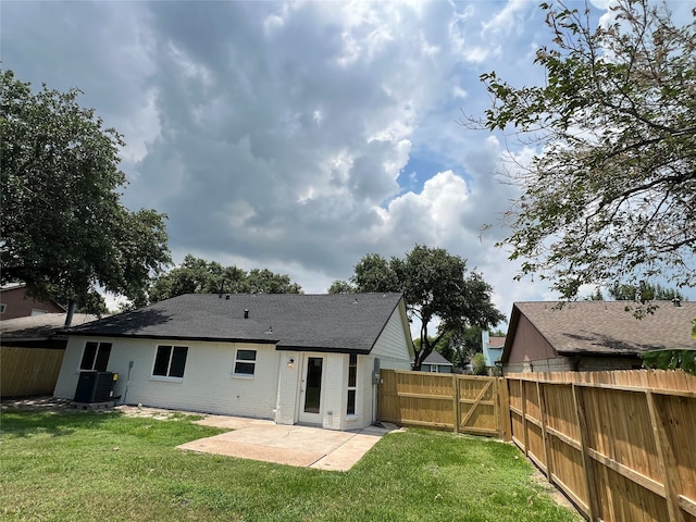 back of property featuring central air condition unit, a patio, and a lawn