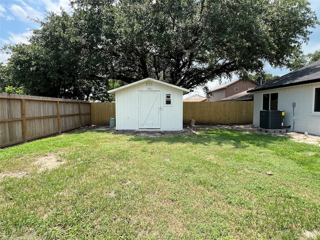 view of yard featuring a shed and central AC