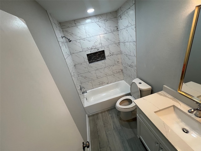 full bathroom with tiled shower / bath combo, vanity, hardwood / wood-style floors, and toilet