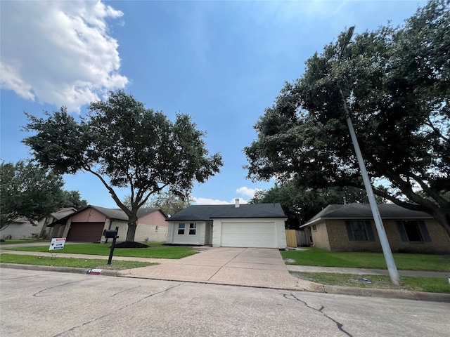 ranch-style house featuring a garage and a front yard