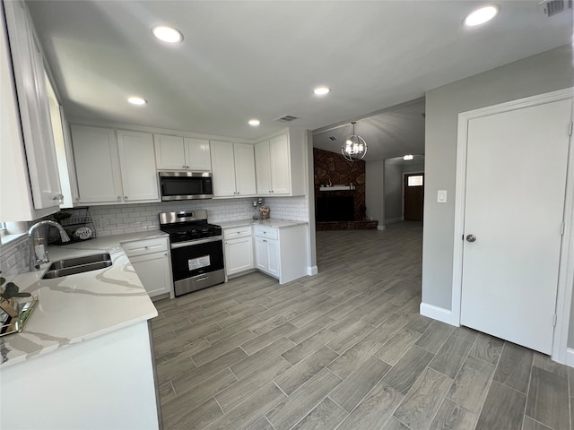 kitchen featuring white cabinetry, light hardwood / wood-style floors, sink, and stainless steel appliances