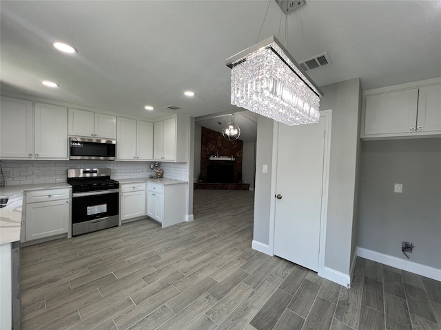 kitchen featuring light hardwood / wood-style floors, appliances with stainless steel finishes, and white cabinets