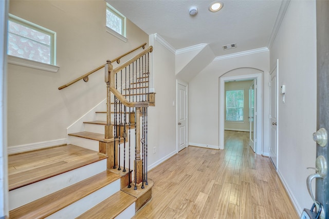 interior space featuring light hardwood / wood-style floors, ornamental molding, and a healthy amount of sunlight