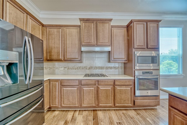 kitchen with decorative backsplash, appliances with stainless steel finishes, light hardwood / wood-style floors, and ornamental molding