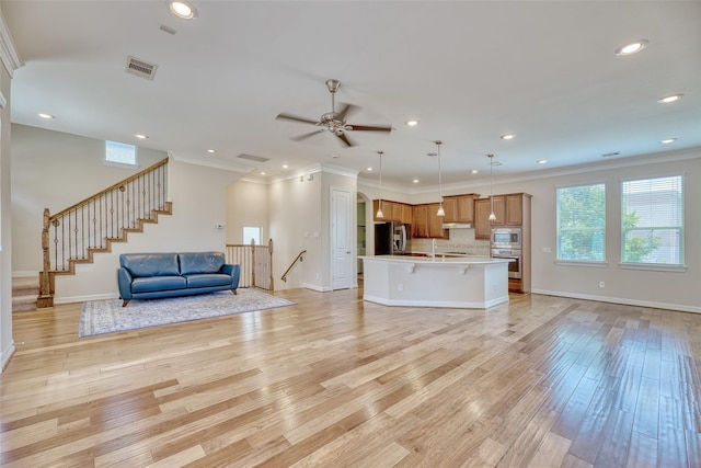 unfurnished living room featuring ceiling fan, light wood-type flooring, and crown molding