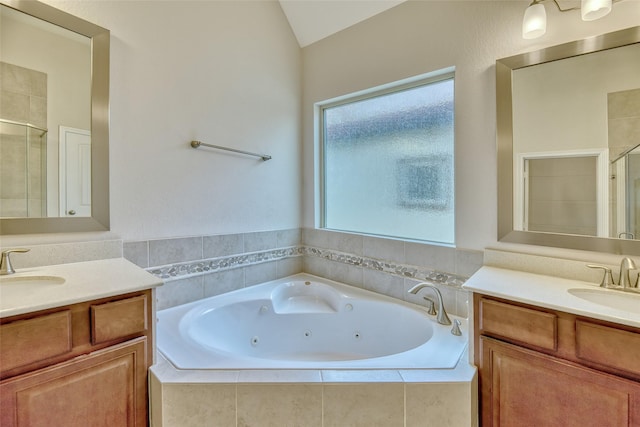 bathroom with vanity, independent shower and bath, and vaulted ceiling