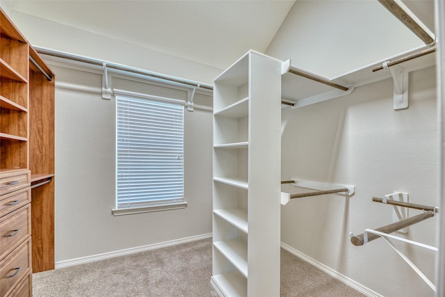 spacious closet with light colored carpet and vaulted ceiling