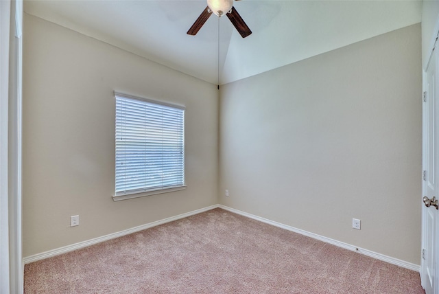 carpeted spare room with ceiling fan and vaulted ceiling