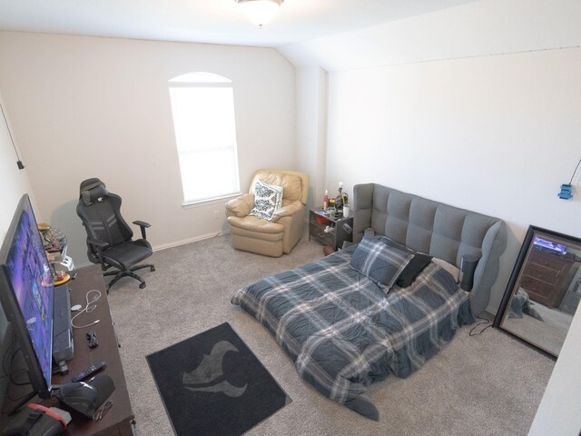 bedroom featuring lofted ceiling and carpet