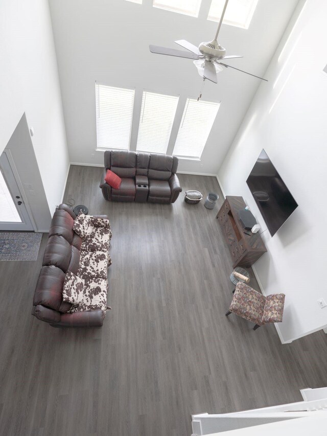 living room with dark hardwood / wood-style flooring and ceiling fan