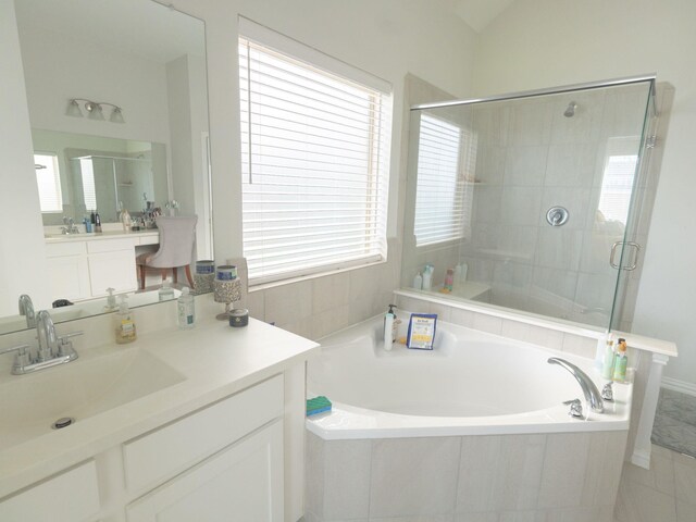 bathroom featuring vaulted ceiling, plus walk in shower, a healthy amount of sunlight, and vanity