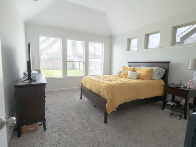 bedroom with lofted ceiling and light colored carpet