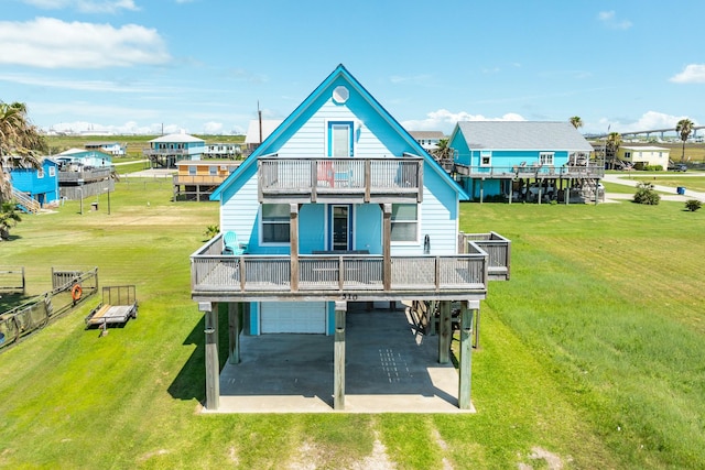 back of property with a garage, a yard, and a balcony