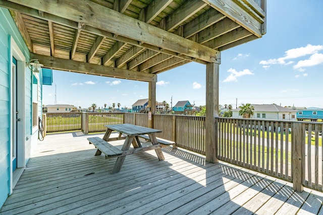 wooden terrace with outdoor dining area and a residential view