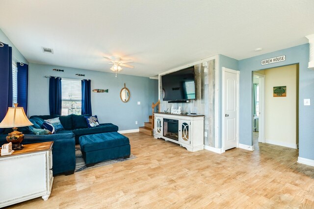 living room featuring light hardwood / wood-style floors and ceiling fan