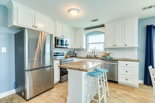kitchen featuring stainless steel appliances, visible vents, a sink, and tasteful backsplash