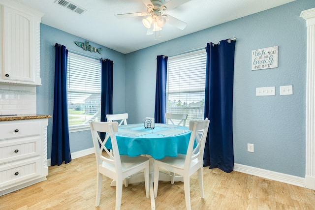 dining space featuring light wood-style flooring, visible vents, baseboards, and ceiling fan