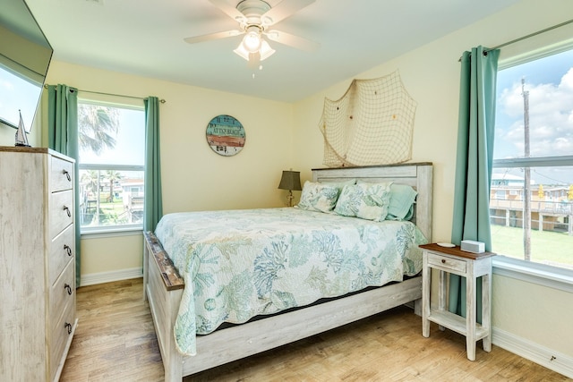 bedroom with ceiling fan, baseboards, and wood finished floors