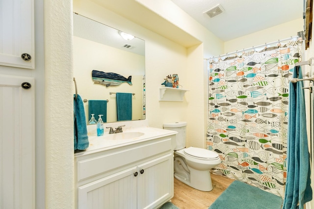 full bathroom with wood finished floors, visible vents, vanity, and toilet