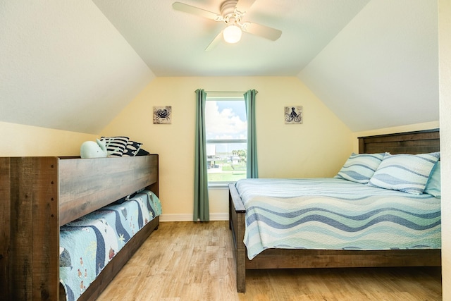 bedroom with ceiling fan, light hardwood / wood-style floors, and vaulted ceiling