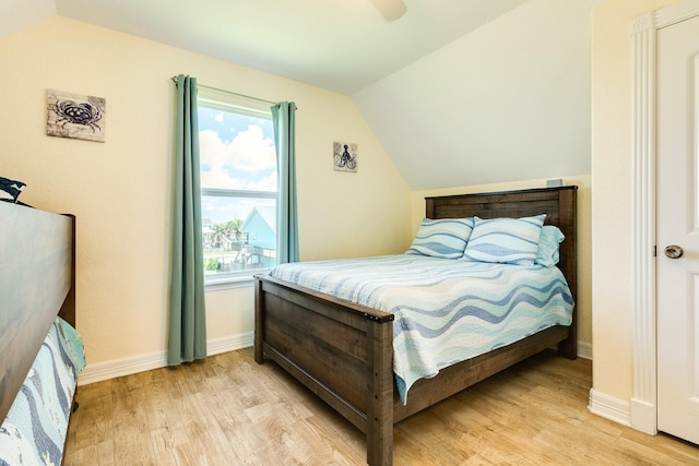 bedroom featuring multiple windows, ceiling fan, lofted ceiling, and light wood-type flooring