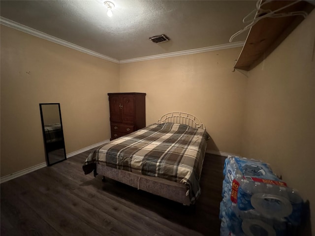 bedroom featuring baseboards, visible vents, dark wood finished floors, and ornamental molding