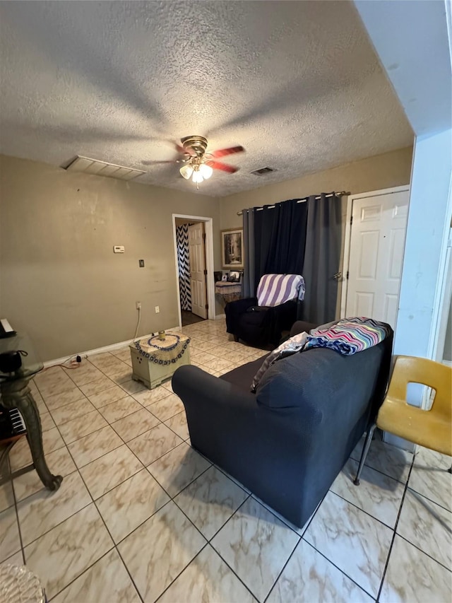 living room with visible vents, ceiling fan, a textured ceiling, and baseboards