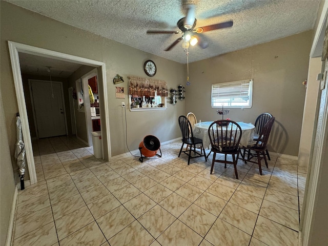 dining room featuring a ceiling fan, a textured ceiling, baseboards, and light tile patterned floors