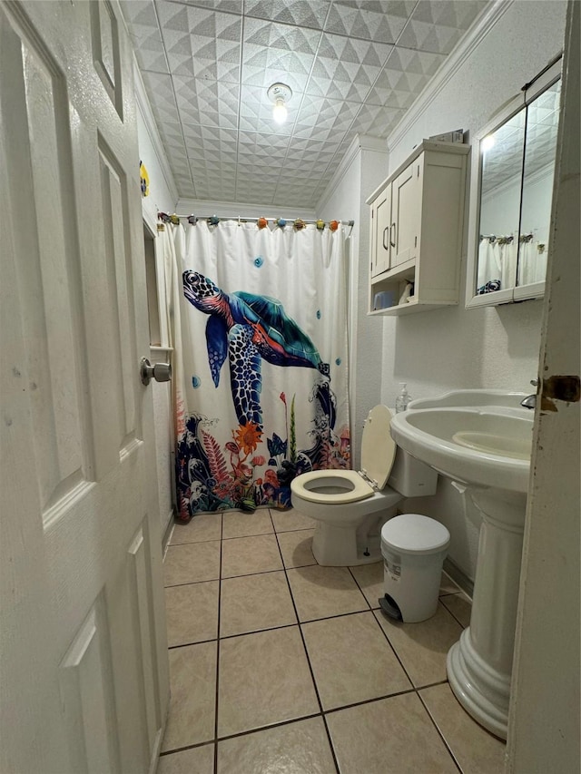 full bathroom with tile patterned flooring, a shower with shower curtain, crown molding, and toilet