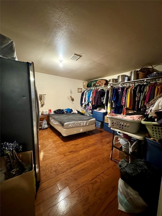 walk in closet with visible vents and wood finished floors