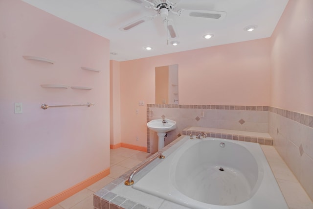 bathroom featuring tile patterned flooring, a relaxing tiled tub, ceiling fan, and sink