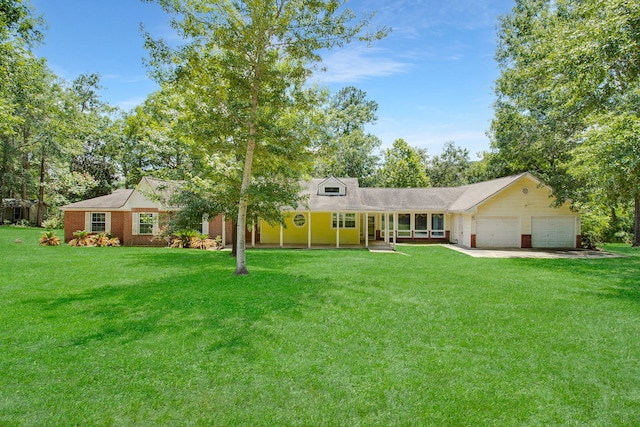 single story home with a porch, a garage, and a front lawn