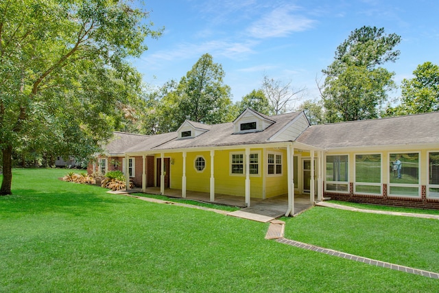 rear view of house with a lawn and a patio