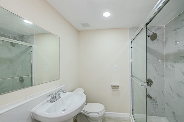 bathroom with sink, walk in shower, and toilet