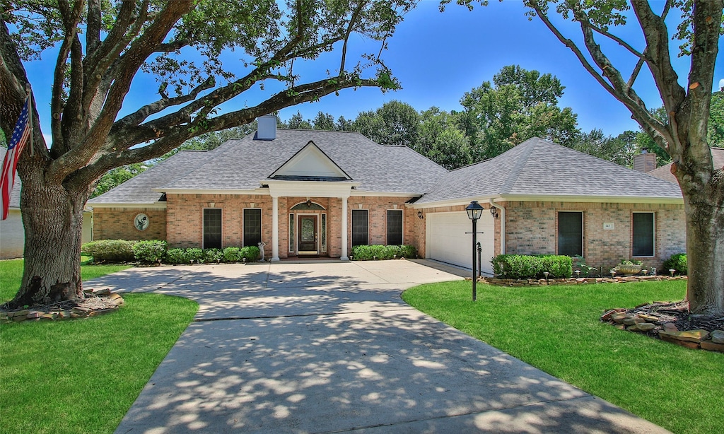 ranch-style home with a garage and a front lawn