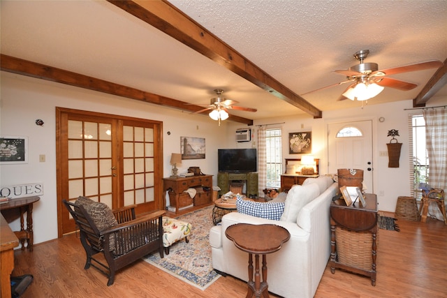 living room with a textured ceiling, ceiling fan, beamed ceiling, and hardwood / wood-style flooring