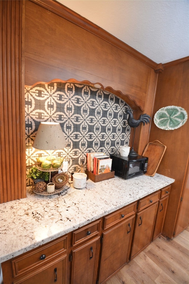 kitchen with light hardwood / wood-style flooring and light stone counters