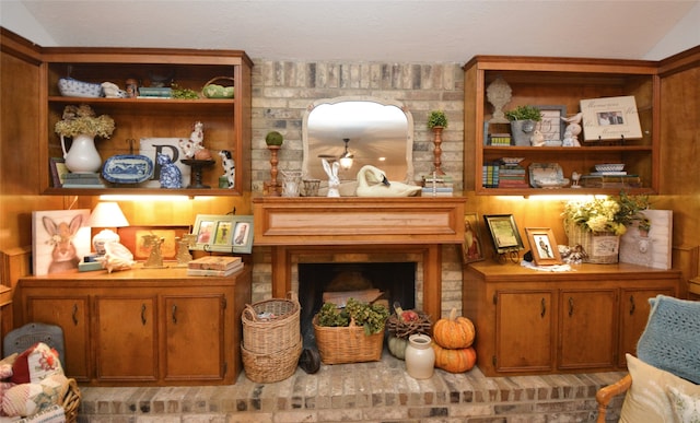 interior space featuring a brick fireplace and lofted ceiling