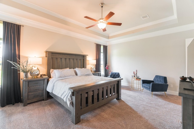 carpeted bedroom featuring a tray ceiling, ceiling fan, and crown molding