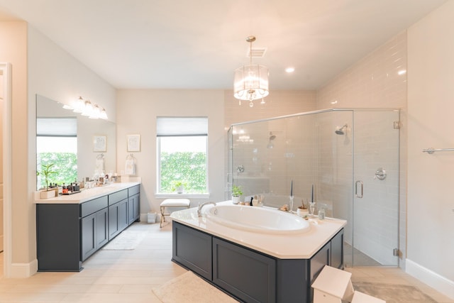 bathroom featuring a notable chandelier, vanity, and shower with separate bathtub