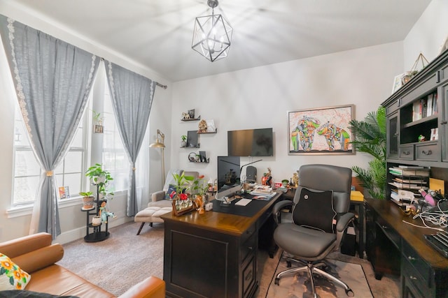 home office with carpet flooring and an inviting chandelier