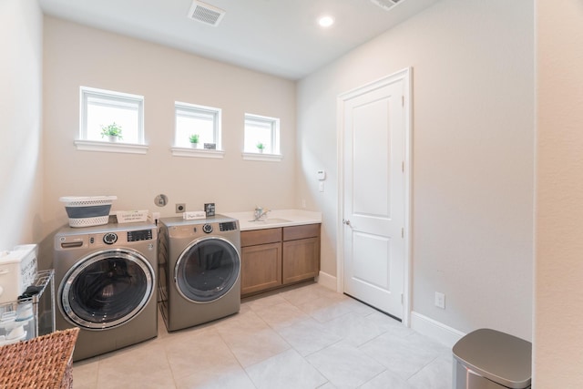 laundry room with washing machine and dryer, a healthy amount of sunlight, sink, and cabinets