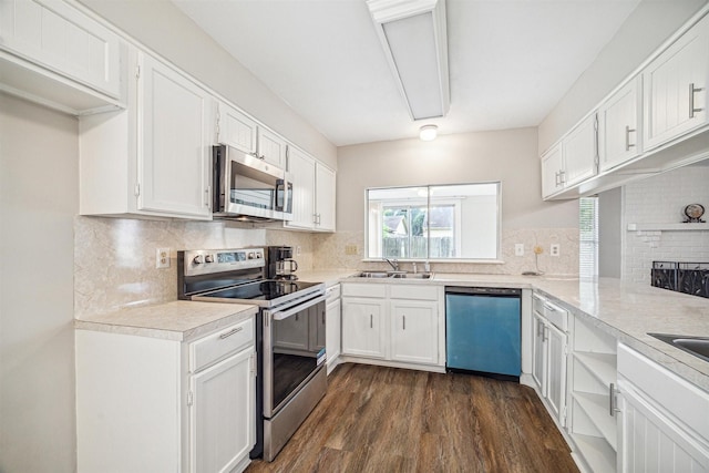 kitchen with appliances with stainless steel finishes, tasteful backsplash, dark wood-type flooring, sink, and white cabinetry