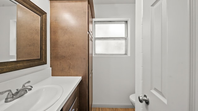 bathroom with vanity, wood-type flooring, and toilet