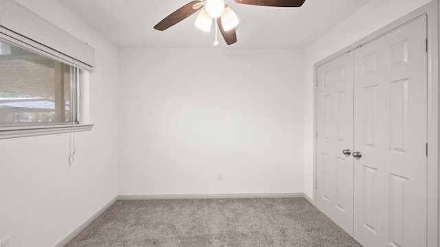 carpeted empty room featuring ceiling fan