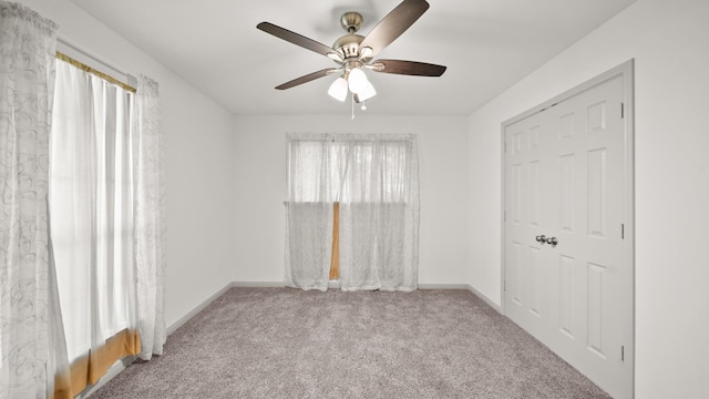 spare room featuring plenty of natural light, ceiling fan, and light colored carpet