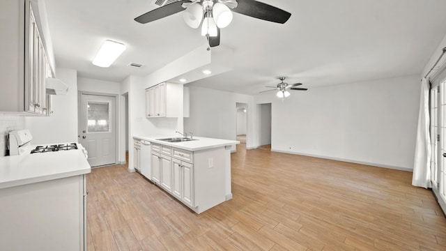 kitchen featuring white cabinets, light wood-type flooring, and a healthy amount of sunlight