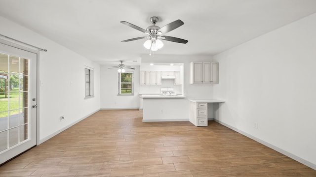 interior space featuring ceiling fan, built in desk, light wood-type flooring, and range