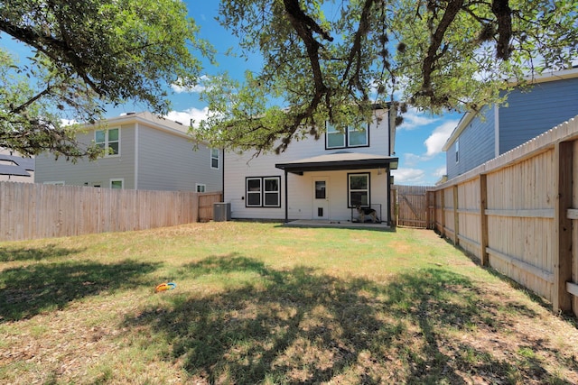 rear view of house with a patio, central AC unit, and a lawn